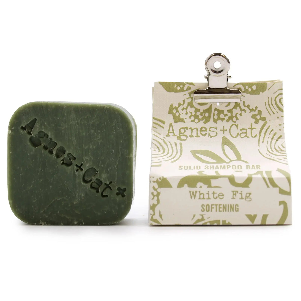 Pastilla de champú sólido verde "Agnes + Cat" de Higo Blanco con empaque de papel y clip metálico sobre fondo blanco.