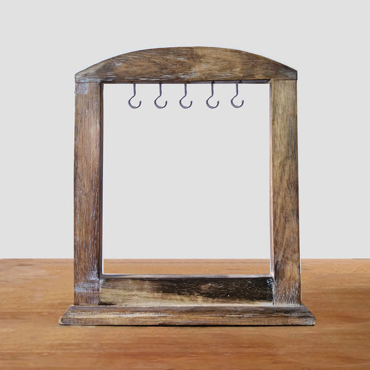Soporte artesanal de madera oscura con marco arqueado y cinco ganchos metálicos para colgar accesorios. 30x25 cm.