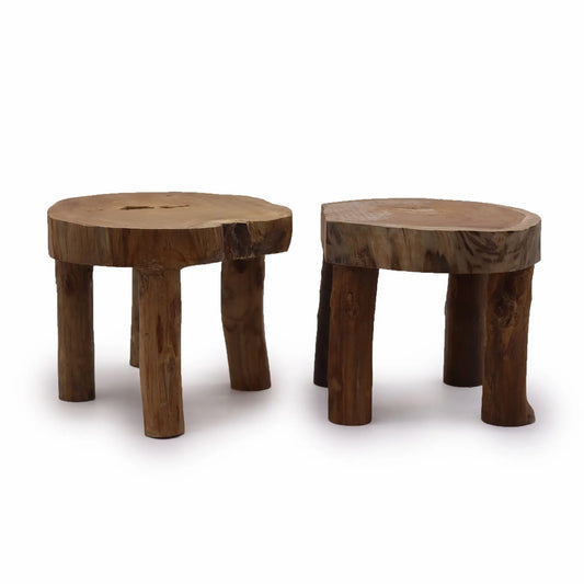 Dos taburetes de madera de teca con superficie rústica circular y tres patas, acabado natural sobre fondo blanco.