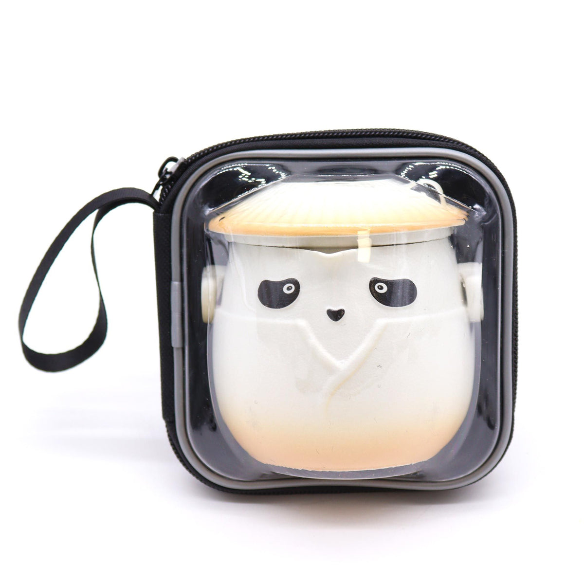 Tetera de cerámica blanca con diseño de panda y sombrero naranja, guardada en un estuche portátil con cierre.