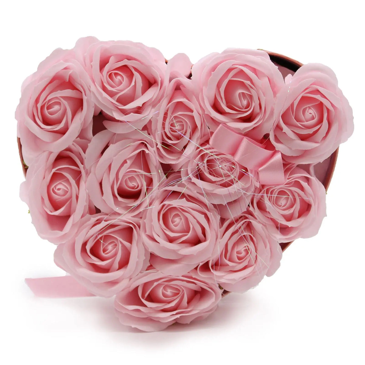 Caja en forma de corazón con 13 rosas de jabón color rosa pastel, decorada con un lazo de seda y fondo blanco.