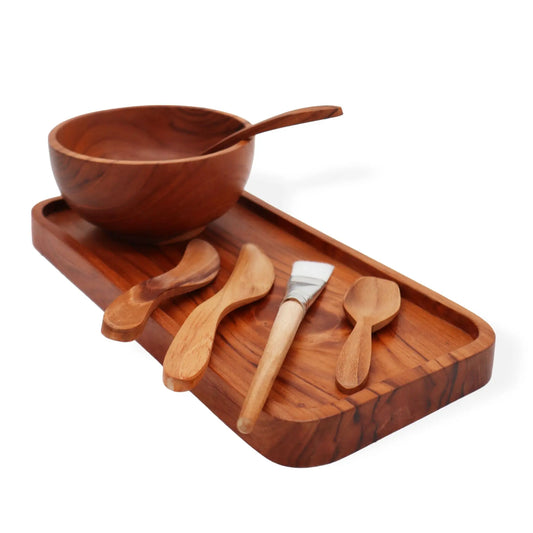 Kit de spa con cuenco, bandeja y utensilios de madera natural con brocha aplicadora sobre fondo blanco