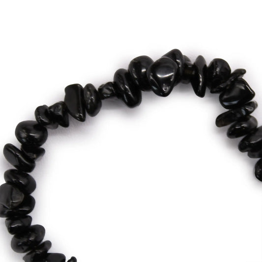 Pulsera elástica hecha con fragmentos pulidos de ágata negra irregular sobre fondo blanco.
