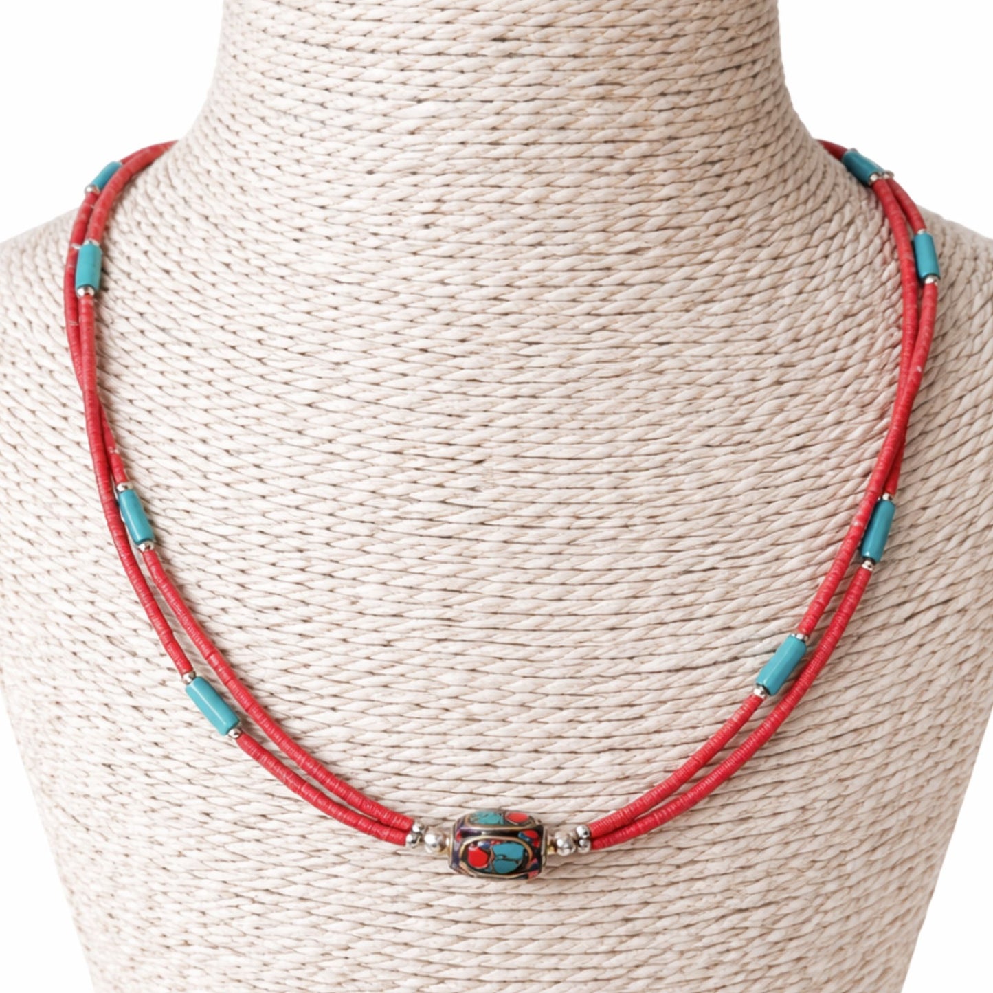 Collar artesanal rojo y turquesa con cuentas de metal, estilo bohemio y materiales naturales.