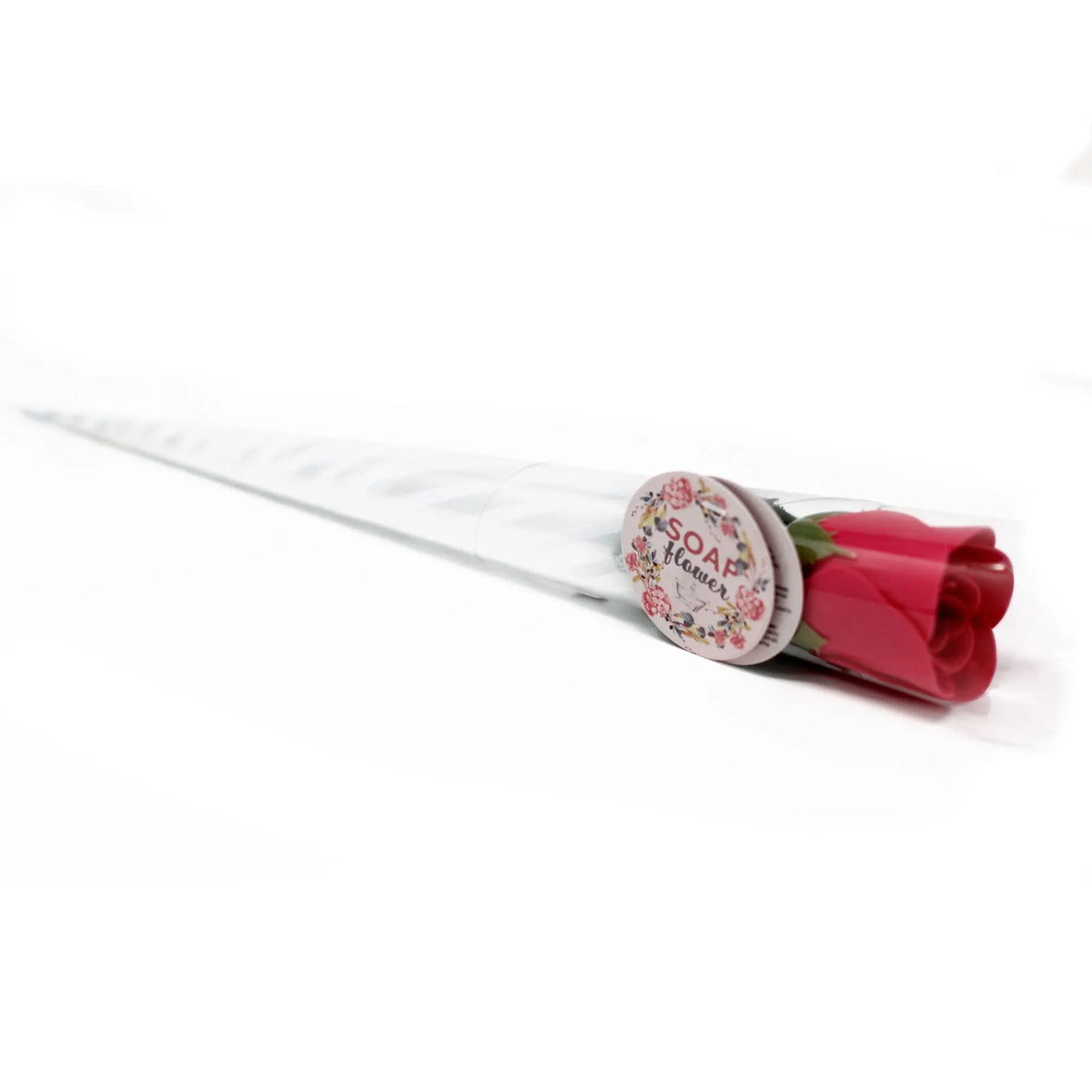 Rosa roja de jabón envuelta en plástico transparente con forma cónica y etiqueta decorativa.