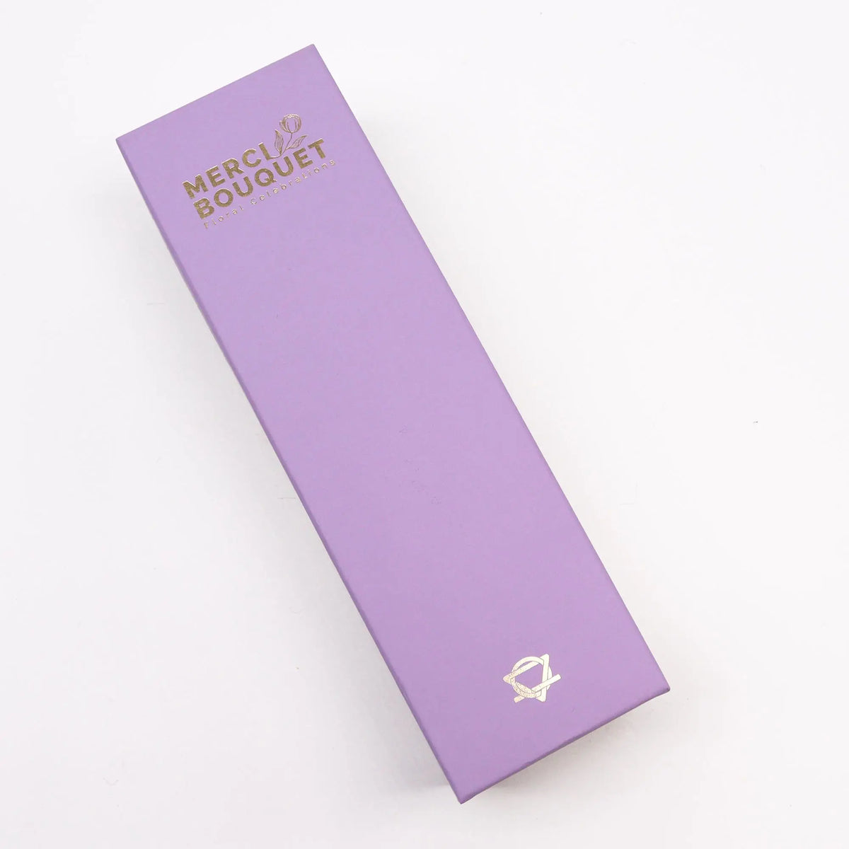 Caja rectangular de regalo color lavanda, diseñada para contener flores de jabón, con detalles decorativos dorados.