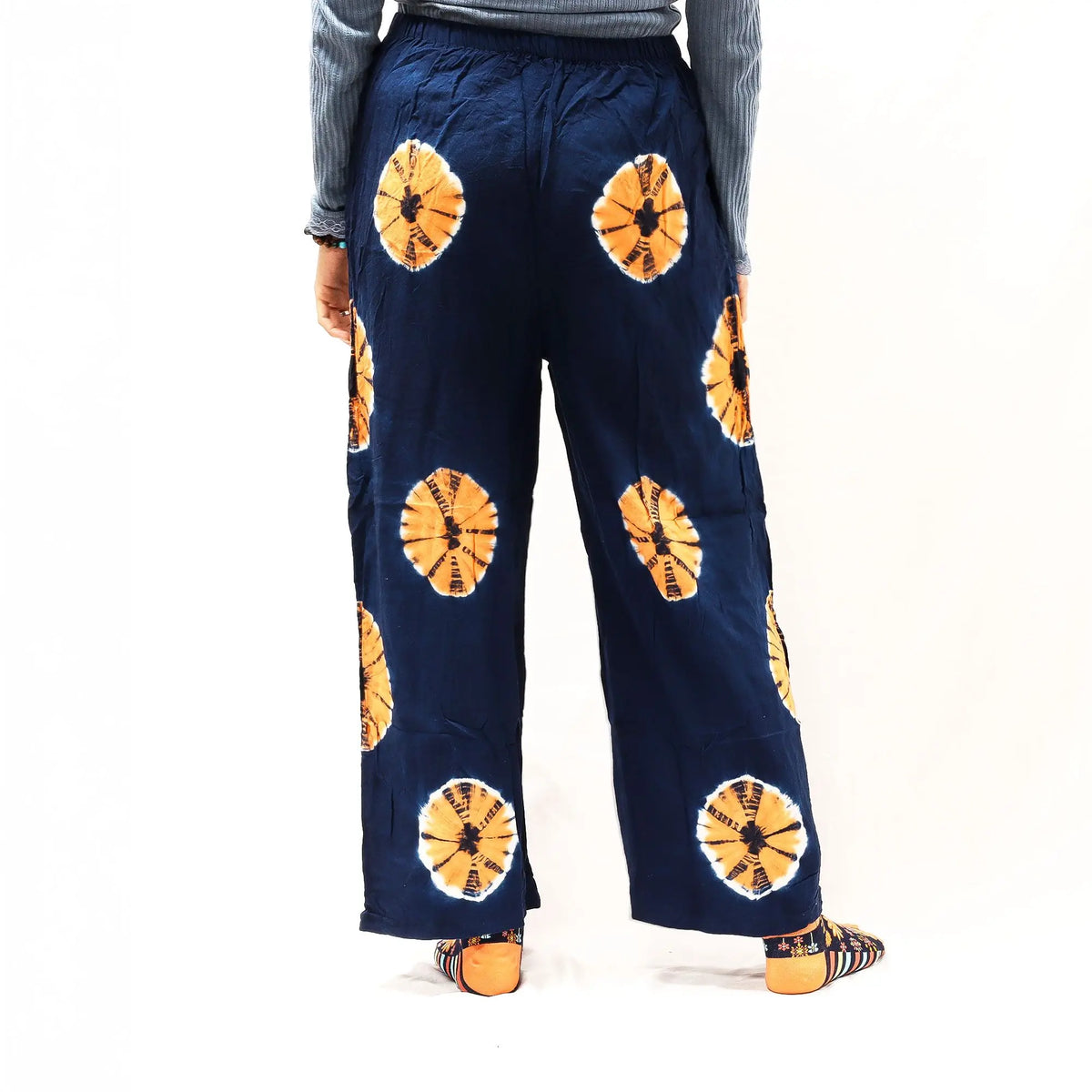 Pantalones de descanso Ancient Wisdom, azul marino con estampado circular naranja, corte holgado y cintura elástica.