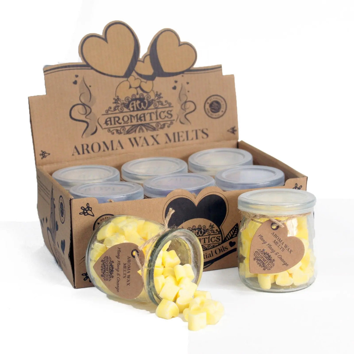 Cajas de cartón con frascos de vidrio llenos de corazones de cera aromática de color amarillo sobre fondo blanco.