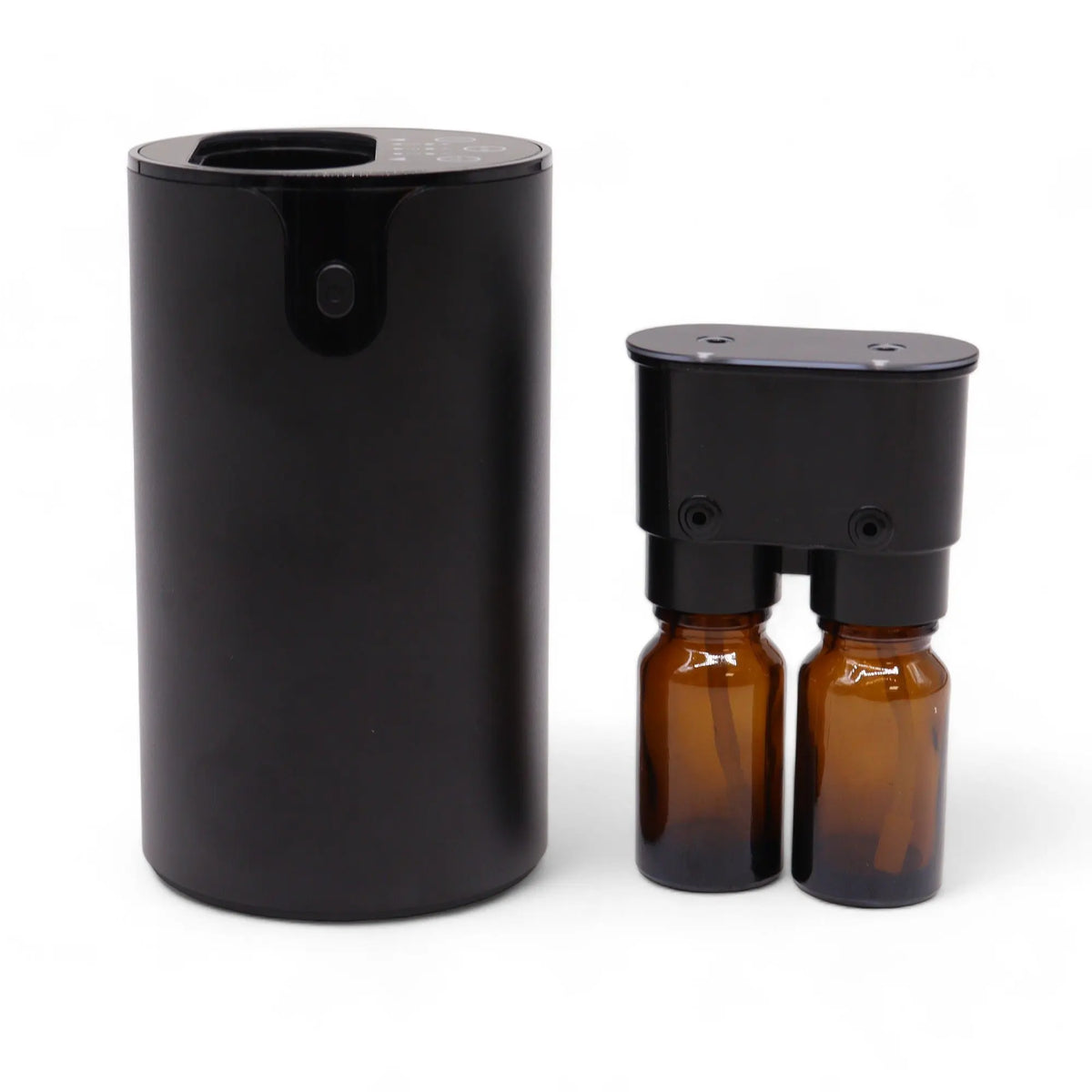 Difusor negro cilíndrico con dos botes de vidrio ámbar independientes para aceites esenciales sin agua. Diseño moderno.