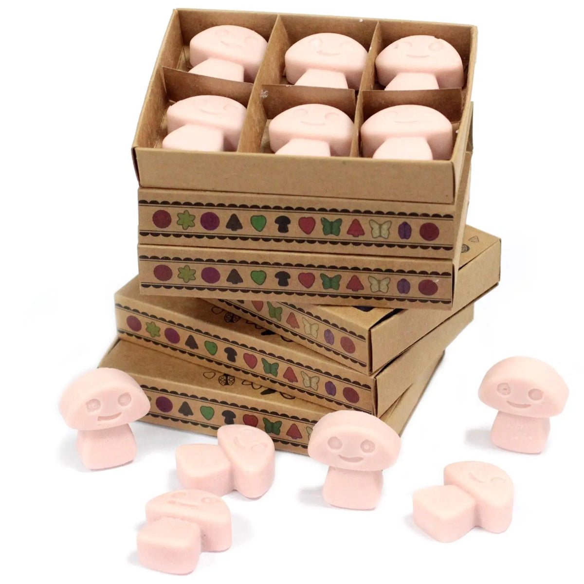 Cajas de cartón con 6 ceras de soja rosas en forma de seta con cara sonriente, decoradas con motivos geométricos.