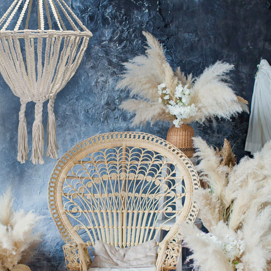 Lámpara colgante de macramé color crema con diseño de gota estilo bohemio sobre un fondo azul texturizado