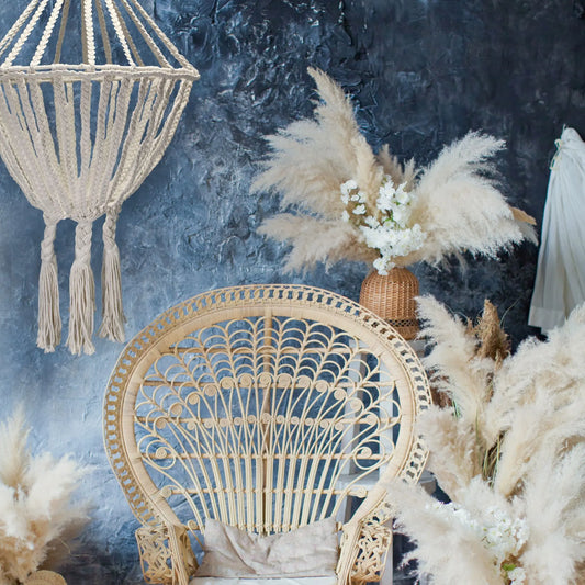 Lámpara colgante de macramé color crema con diseño de gota estilo bohemio sobre un fondo azul texturizado