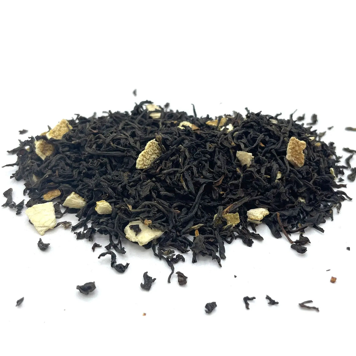 Montón de hebras de té negro seco mezcladas con trozos de cáscara de naranja sobre un fondo blanco limpio