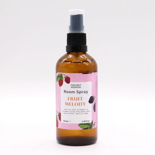 Spray de ambiente de 100ml en botella de vidrio ámbar con etiqueta rosa ilustrada con frutas, sobre fondo blanco.