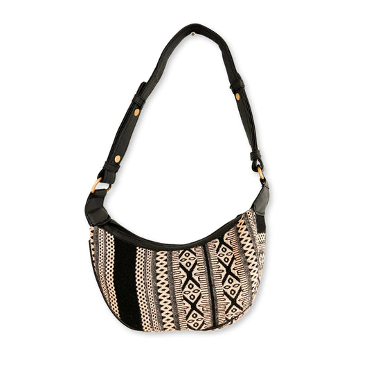 Bolso hobo curvo de jacquard gris y negro con patrón geométrico, correa negra ajustable y detalles en herrajes dorados.