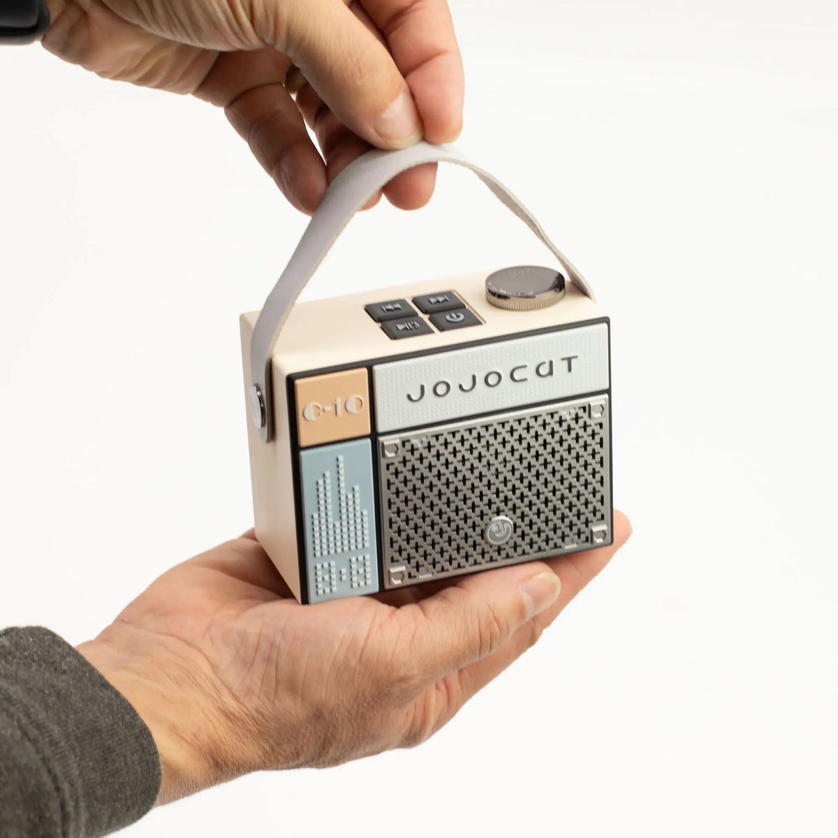 Altavoz Bluetooth Jojocut C10 estilo retro beige y azul, con asa de tela, botones superiores y rejilla metálica.