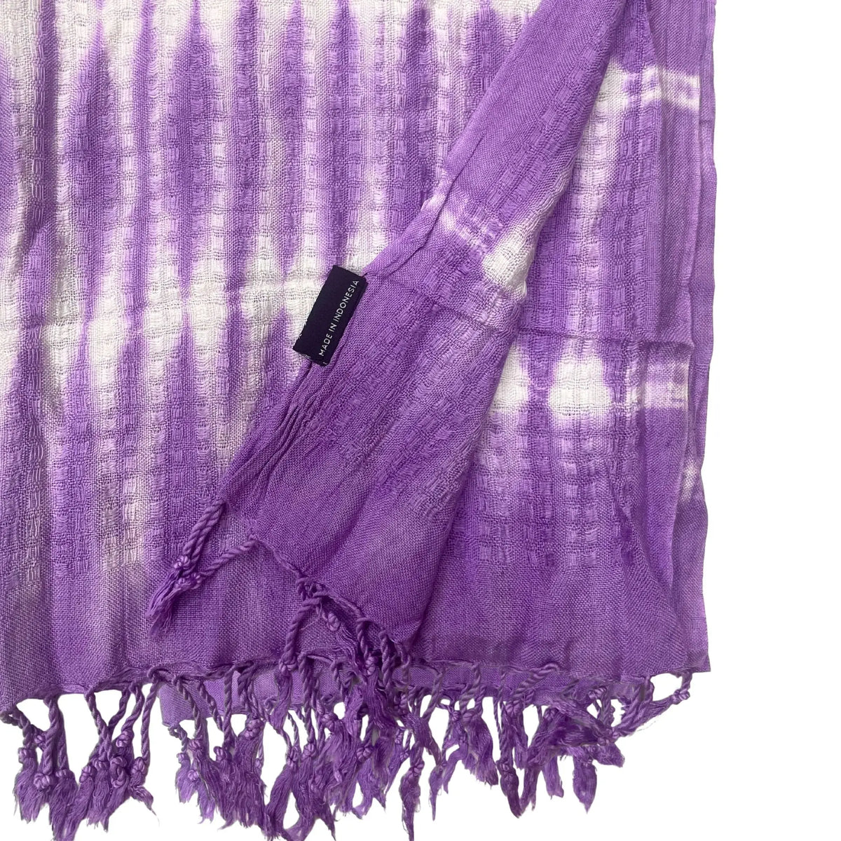 Bufanda color lavanda y blanco con patrón de rayas verticales, textura tipo rejilla y flecos en los extremos.