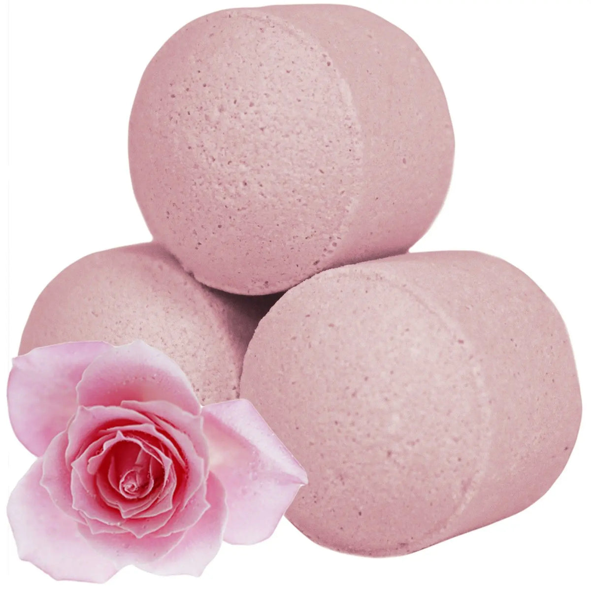 Tres mini bombas de baño efervescentes de color rosa claro en forma cilíndrica junto a una rosa fresca rosada.