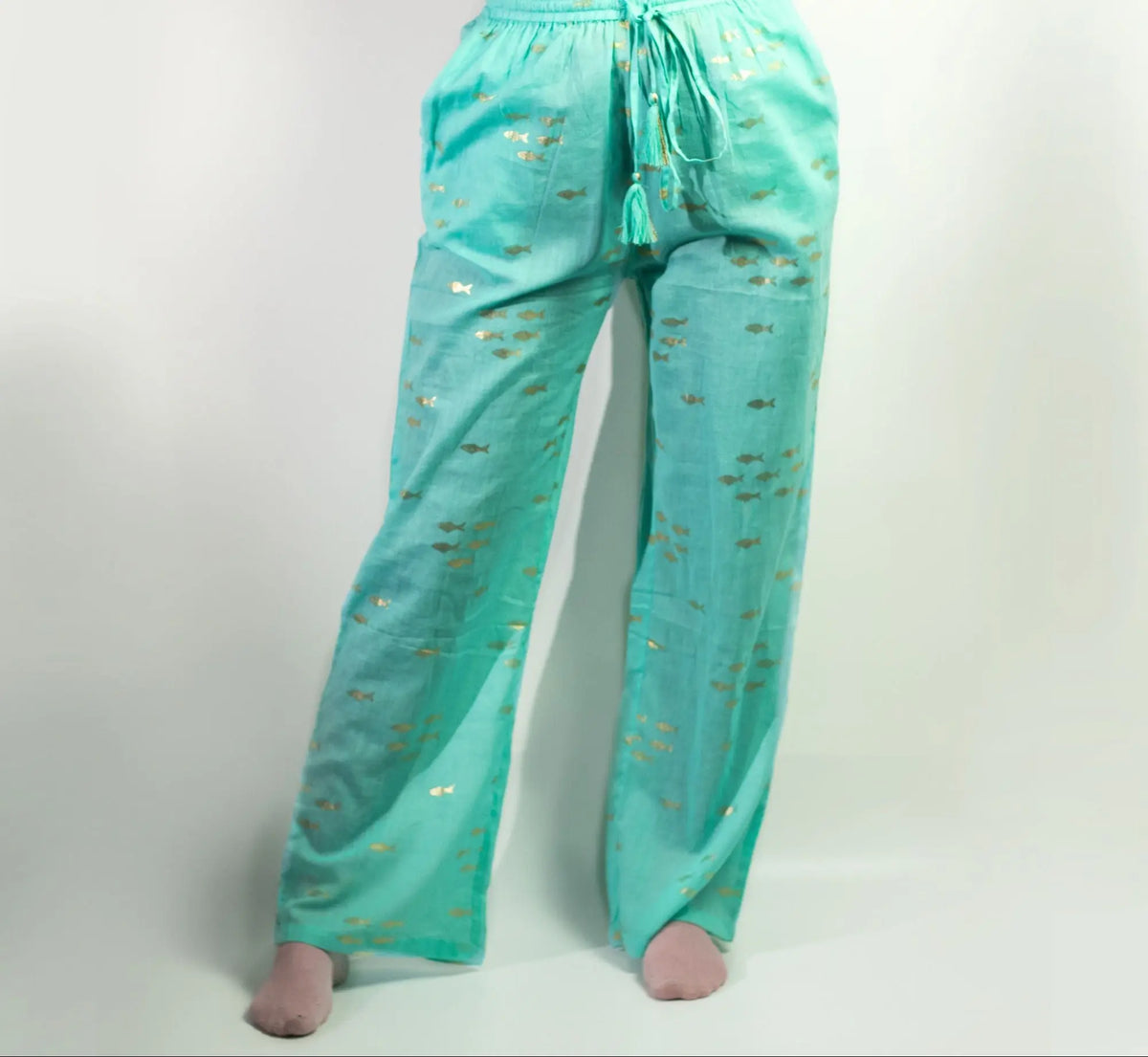 Pantalones de algodón turquesa con estampado de peces dorados, corte holgado, cintura elástica y cordón con borlas.
