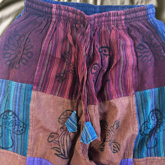 Pantalones de algodón morados y multicolores con diseño étnico y cinturilla ajustable. Perfectos para un estilo bohemio.