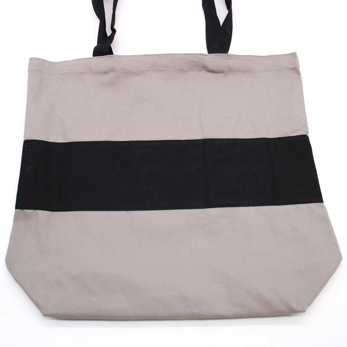 Bolsa de algodón gris con una franja central negra horizontal y asas negras. Diseño rectangular y resistente.
