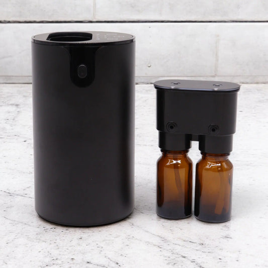 Difusor negro Ancient Wisdom de diseño cilíndrico con dos botes de vidrio ámbar para aceites esenciales.