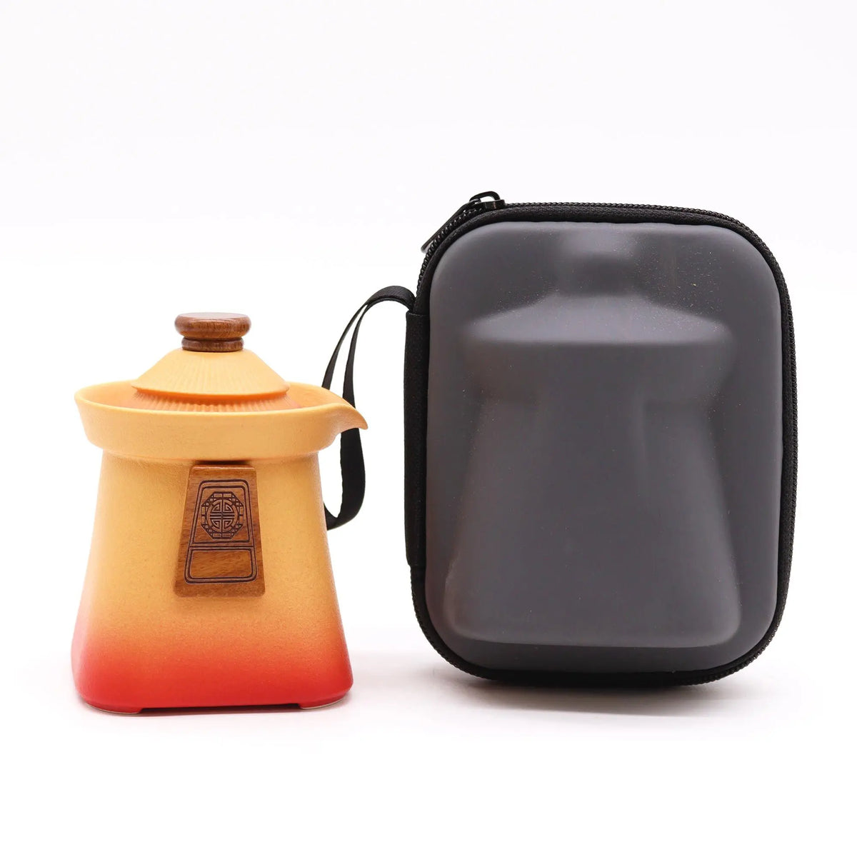 Tetera de cerámica naranja con degradado rojo, detalle de madera y estuche protector gris con cremallera.
