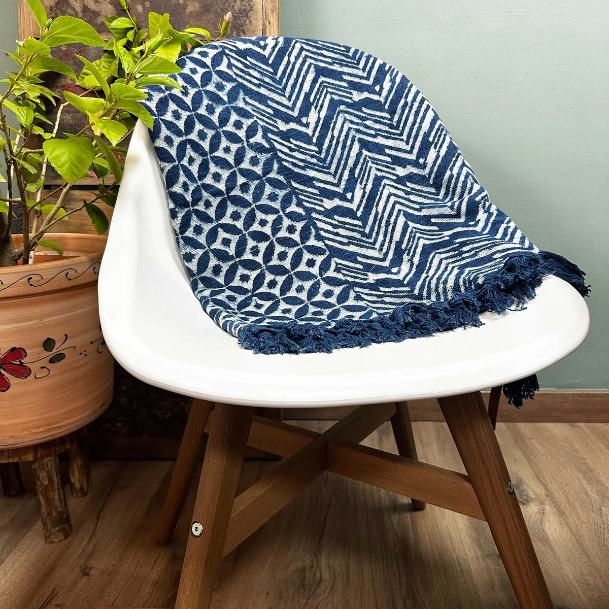 Manta azul marino y blanco con patrones geométricos y flecos, perfecta para decoración moderna.