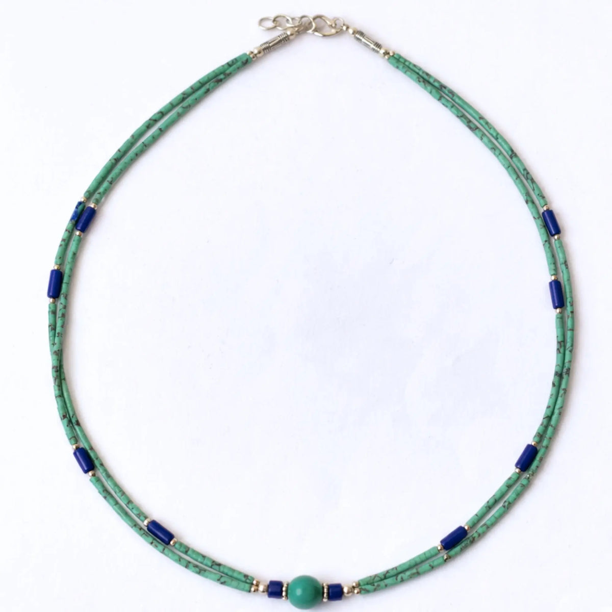 Collar de perlas verdes y azules, hecho de vidrio y metal, con cierre de plata. Estilo moderno y elegante.