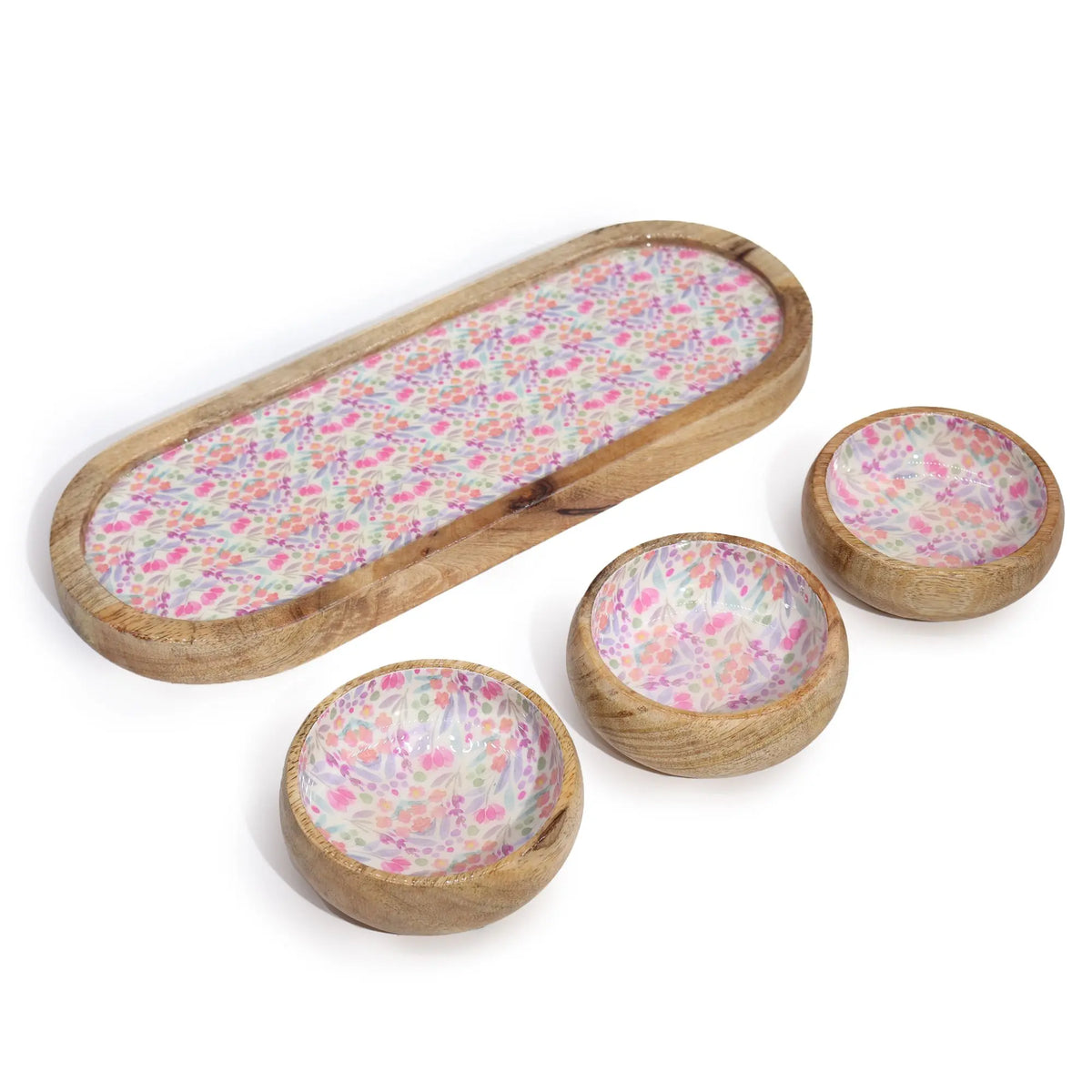 Bandeja alargada y tres cuencos redondos de madera de mango con interior decorado con estampado floral en tonos pastel.