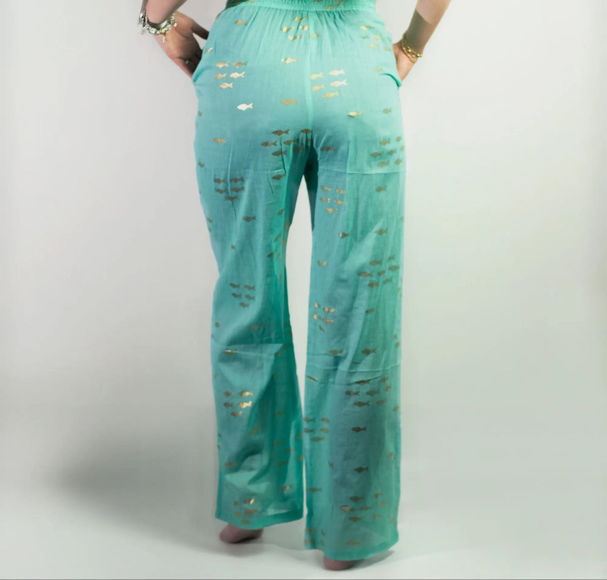 Pantalones lounge de algodón turquesa con estampado de peces dorados, corte recto y cintura elástica.