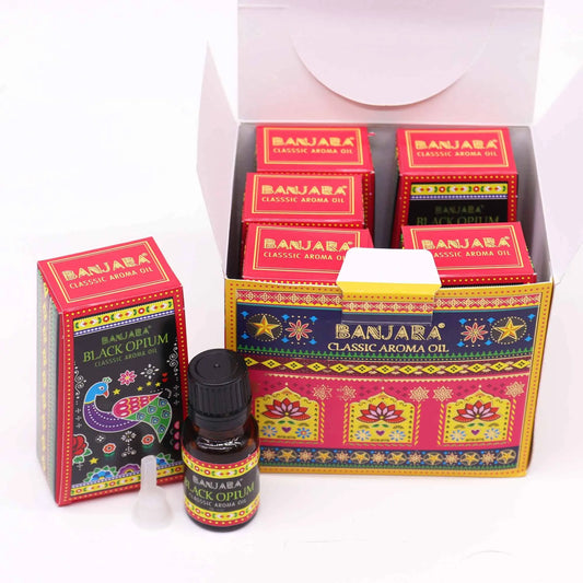 Frascos de aceite aromático y cajas de cartón con diseños indios coloridos, motivos florales y un pavo real.