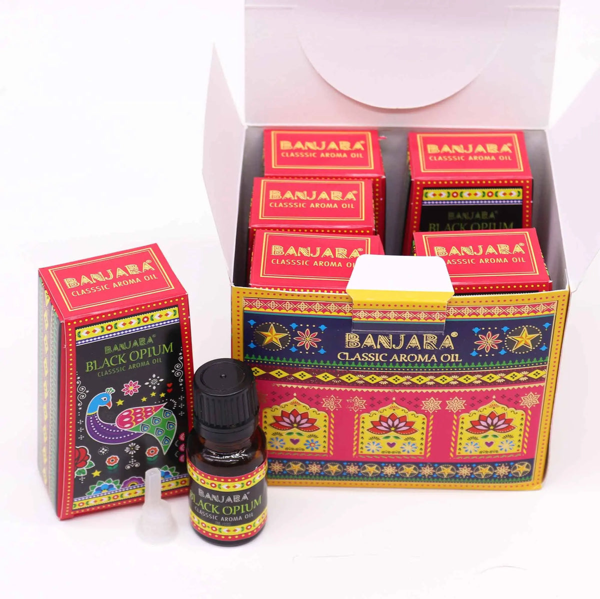 Frascos de aceite aromático y cajas de cartón con diseños indios coloridos, motivos florales y un pavo real.
