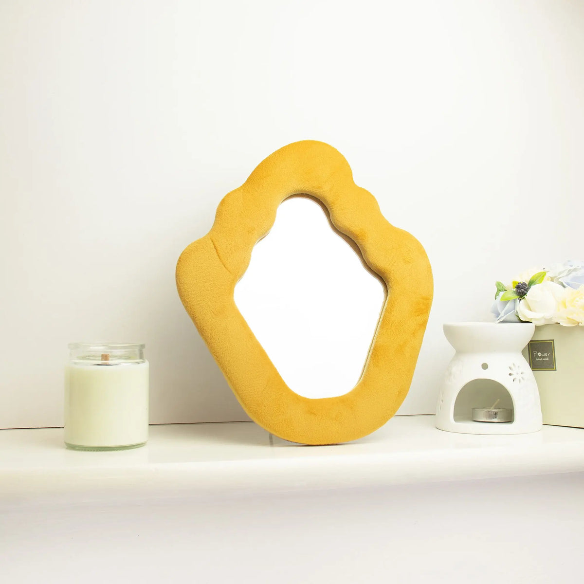 Espejo de pared de terciopelo amarillo en forma orgánica, ideal para decoración moderna y luminosa.