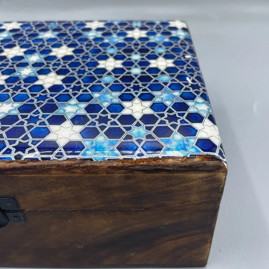 Caja de madera artesanal con tapa esmaltada en tonos azules y blancos con patrón geométrico de estrellas.