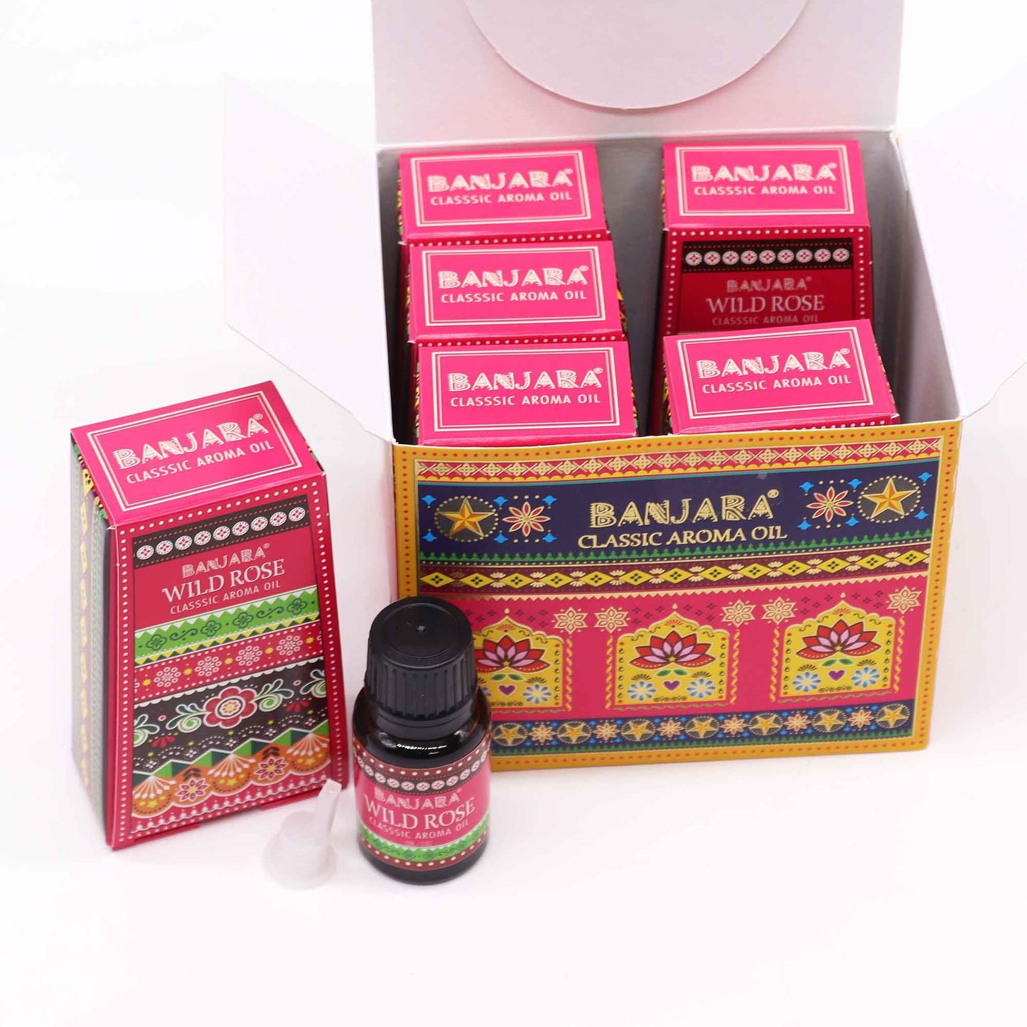 Caja abierta con frascos de aceite de rosa silvestre y envases de cartón decorados con motivos étnicos coloridos.