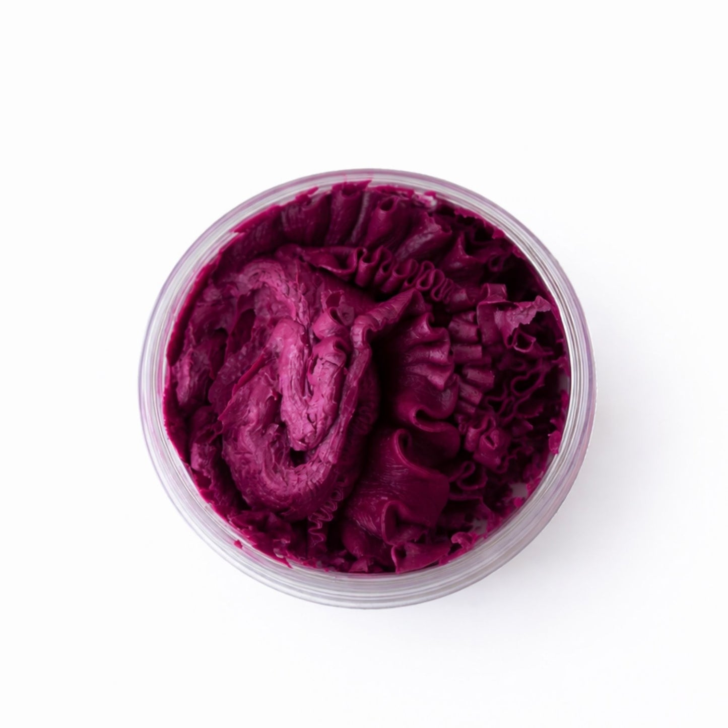 Crema de color púrpura en tarro transparente, con textura suave y rizada, ideal para tratamientos de belleza.