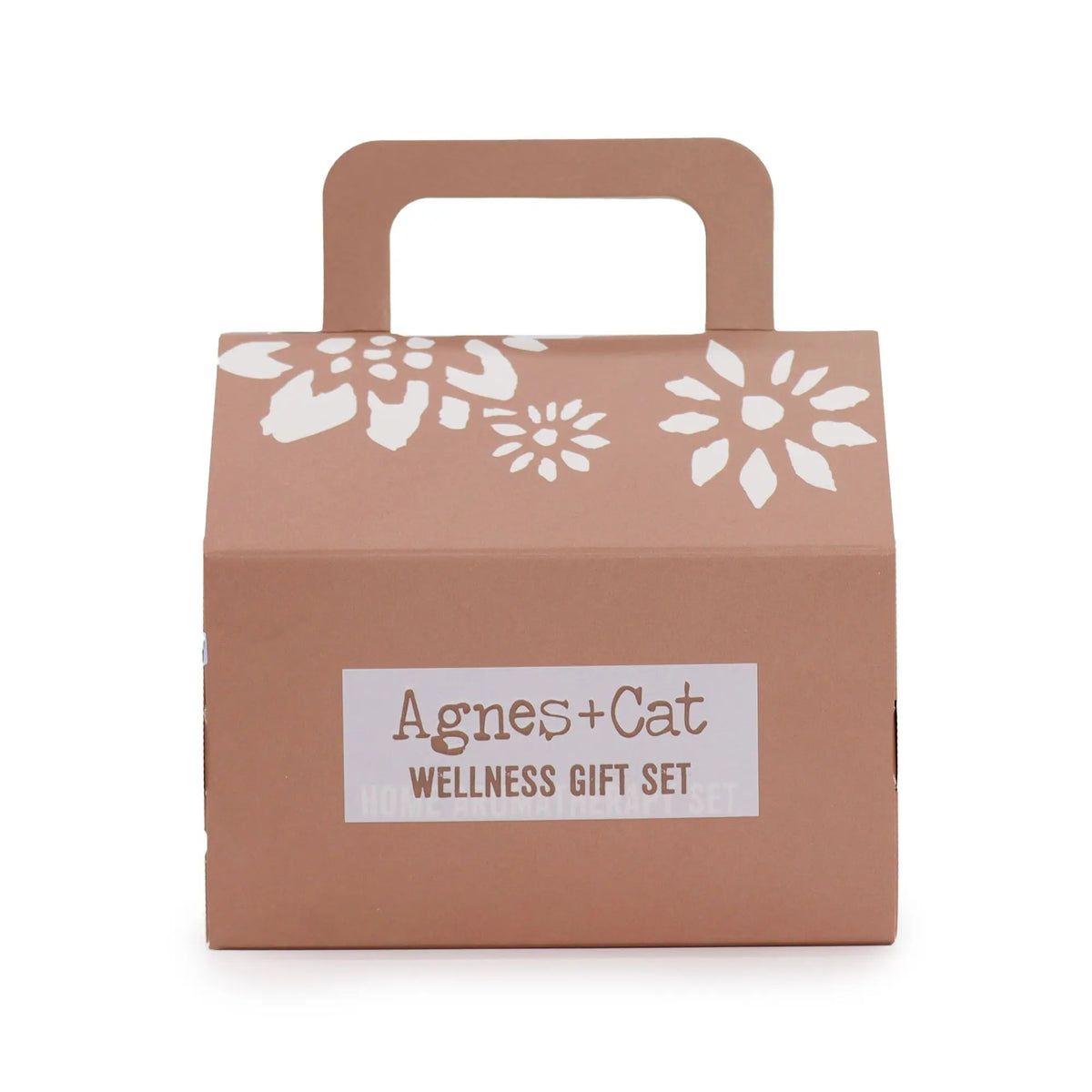 Caja de regalo color terracota con asa, flores blancas impresas y etiqueta con el logo Agnes + Cat Wellness Gift Set.