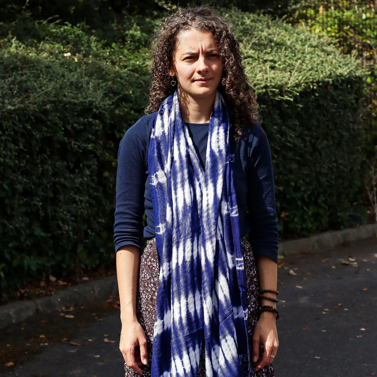 Mujer con estola larga de lino y rayón, diseño de rayas verticales en azul índigo y blanco estilo teñido artesanal.