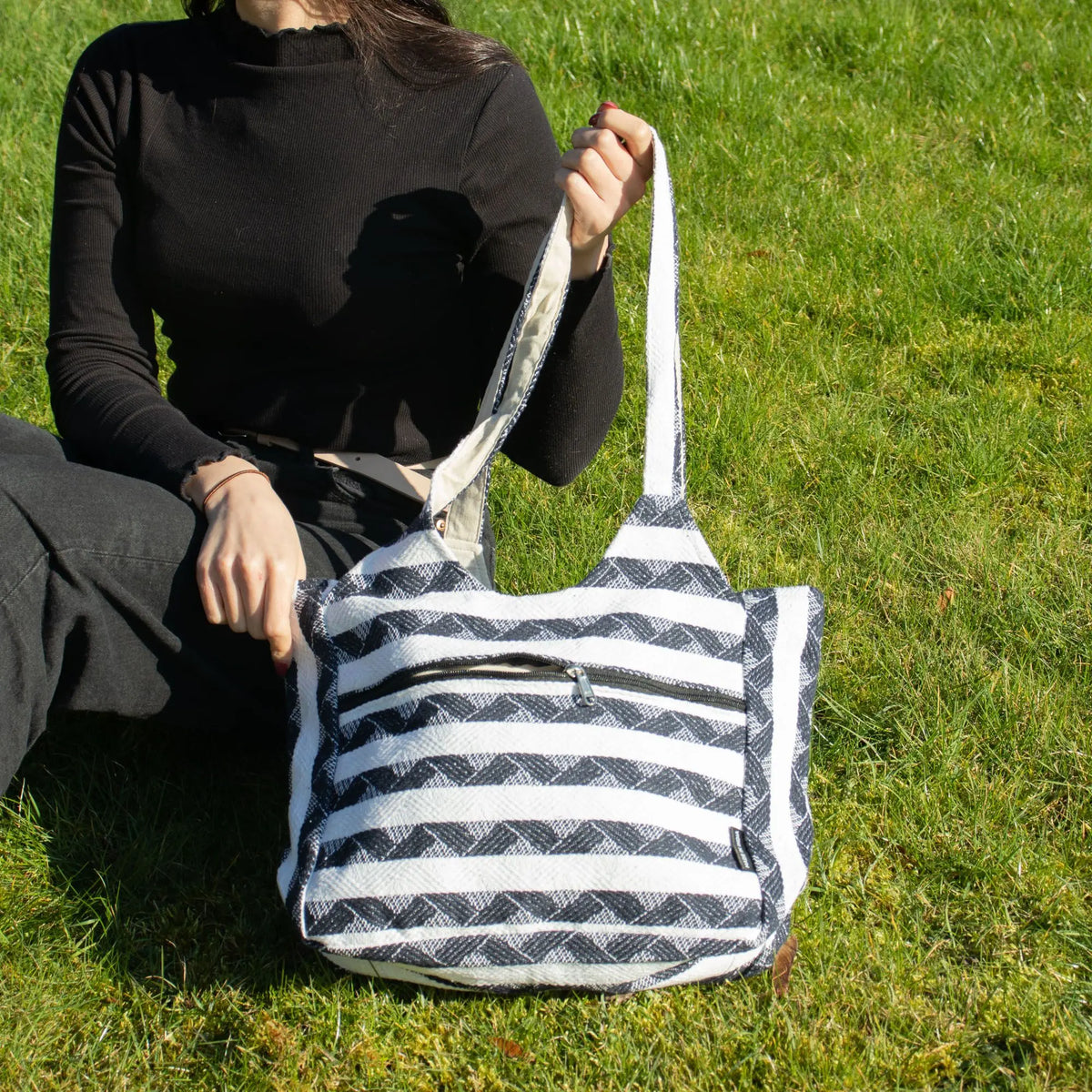 Bolso de tela negro y blanco con rayas, estilo casual, ideal para uso diario.