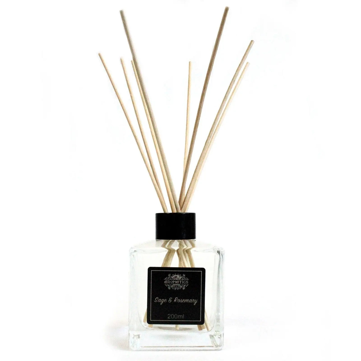 Difusor de vidrio transparente cuadrado con varillas de madera y etiqueta negra de salvia y romero sobre fondo blanco.