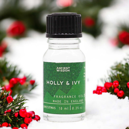 Frasco de vidrio de 10ml con etiqueta verde sobre nieve, rodeado de ramas de acebo con frutos rojos.