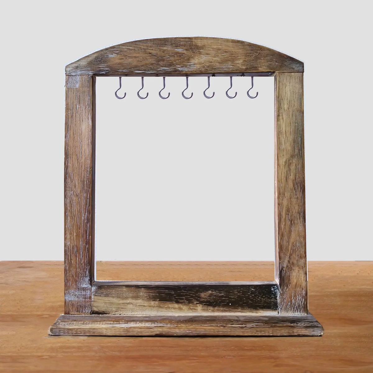Soporte de madera oscura con marco arqueado y siete ganchos metálicos, ideal para exhibición artesanal de 40x30 cm.