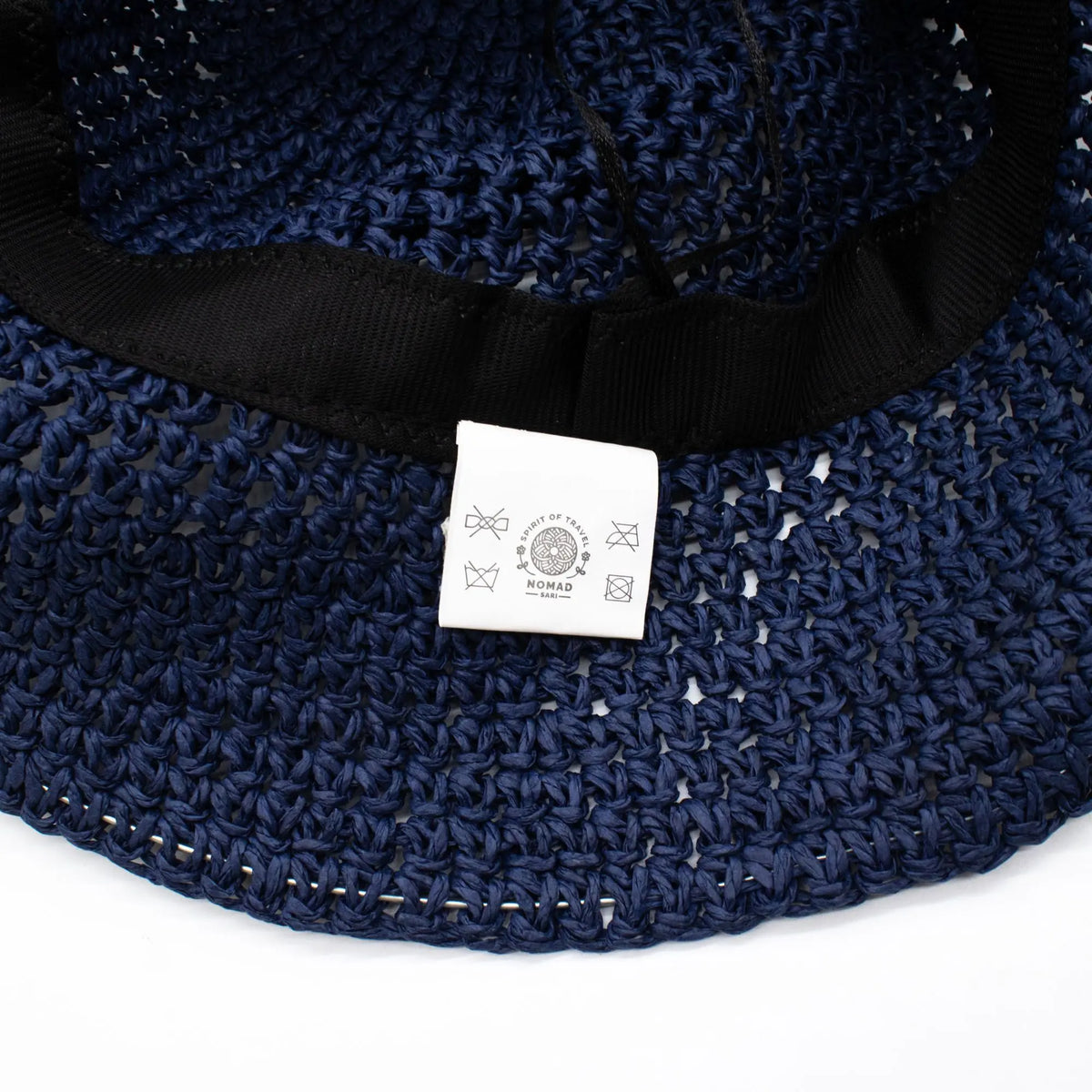 Sombrero de paja azul marino con etiqueta, estilo casual y detalle de cinta negra en el interior.