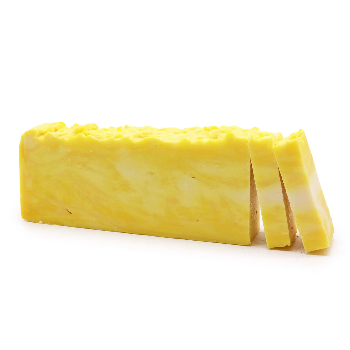Barra rectangular de jabón artesanal amarillo con veteado blanco, incluyendo dos rebanadas cortadas sobre fondo blanco.
