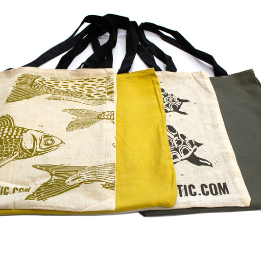Bolsas de algodón reversibles con estampados de peces y tortugas en tonos mostaza, verde oliva y beige con asas negras