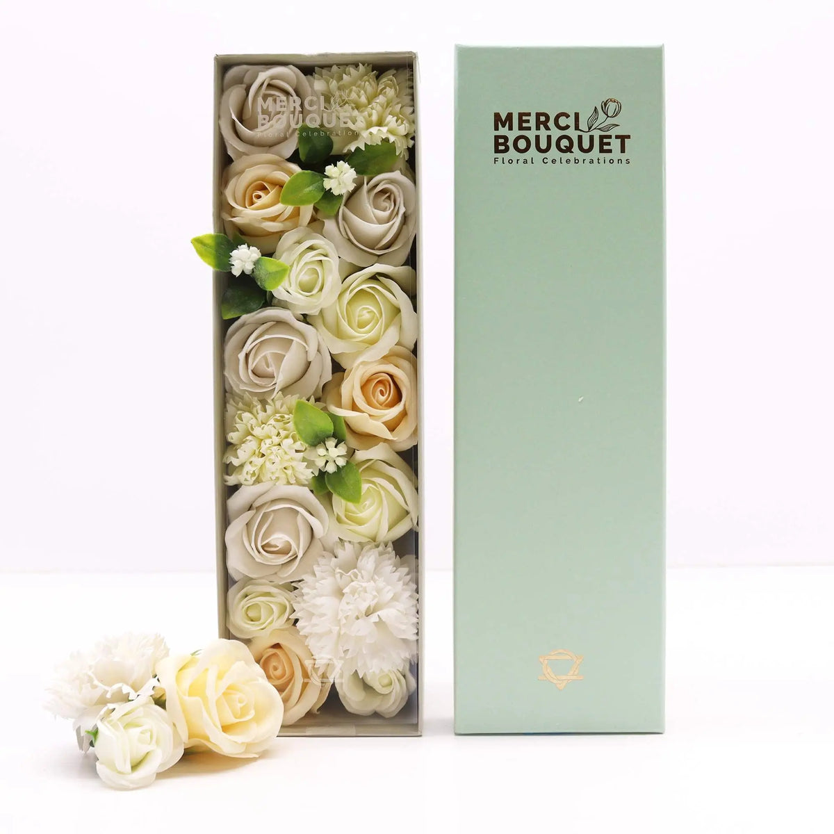 Caja rectangular con rosas y flores de jabón en tonos blanco y marfil junto a una tapa color verde pastel elegante