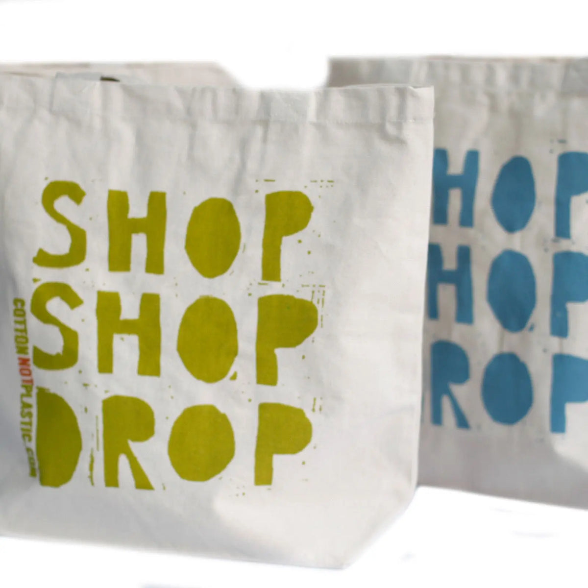 Bolsas de algodón beige con estampado "SHOP SHOP DROP" en colores verde y azul, estilo artesanal y ecológico.