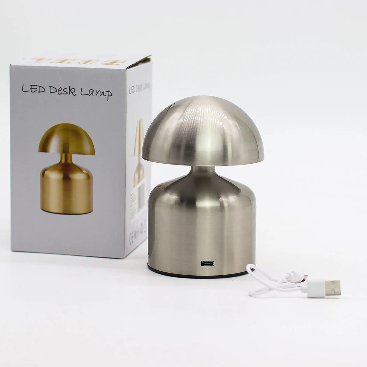 Lámpara de mesa táctil estilo champiñón en metal plateado con puerto de carga USB-C y cable incluido junto a su caja