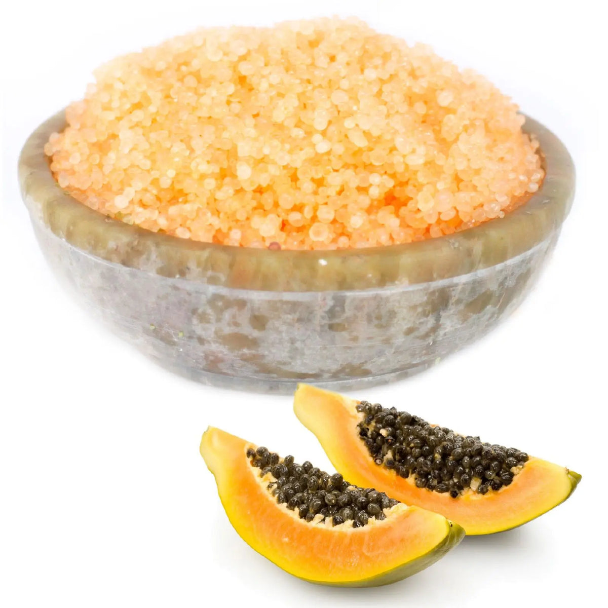 Cuenco de piedra con gránulos aromáticos color naranja y dos trozos de papaya fresca con semillas, sobre fondo blanco.